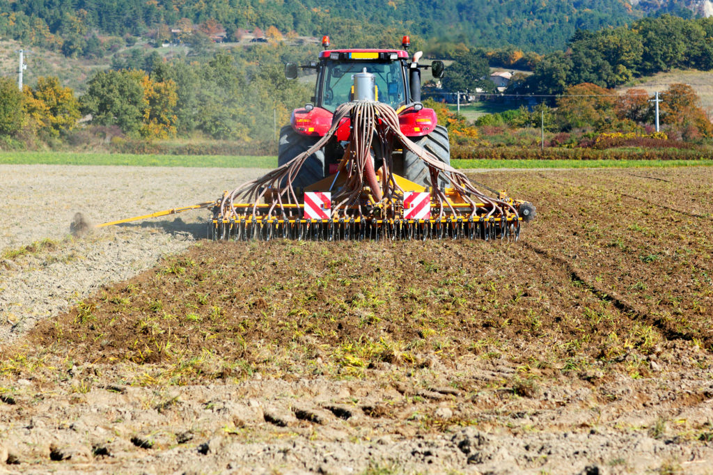 Ploughing heavy tractor during cultivation agriculture works at field with plough