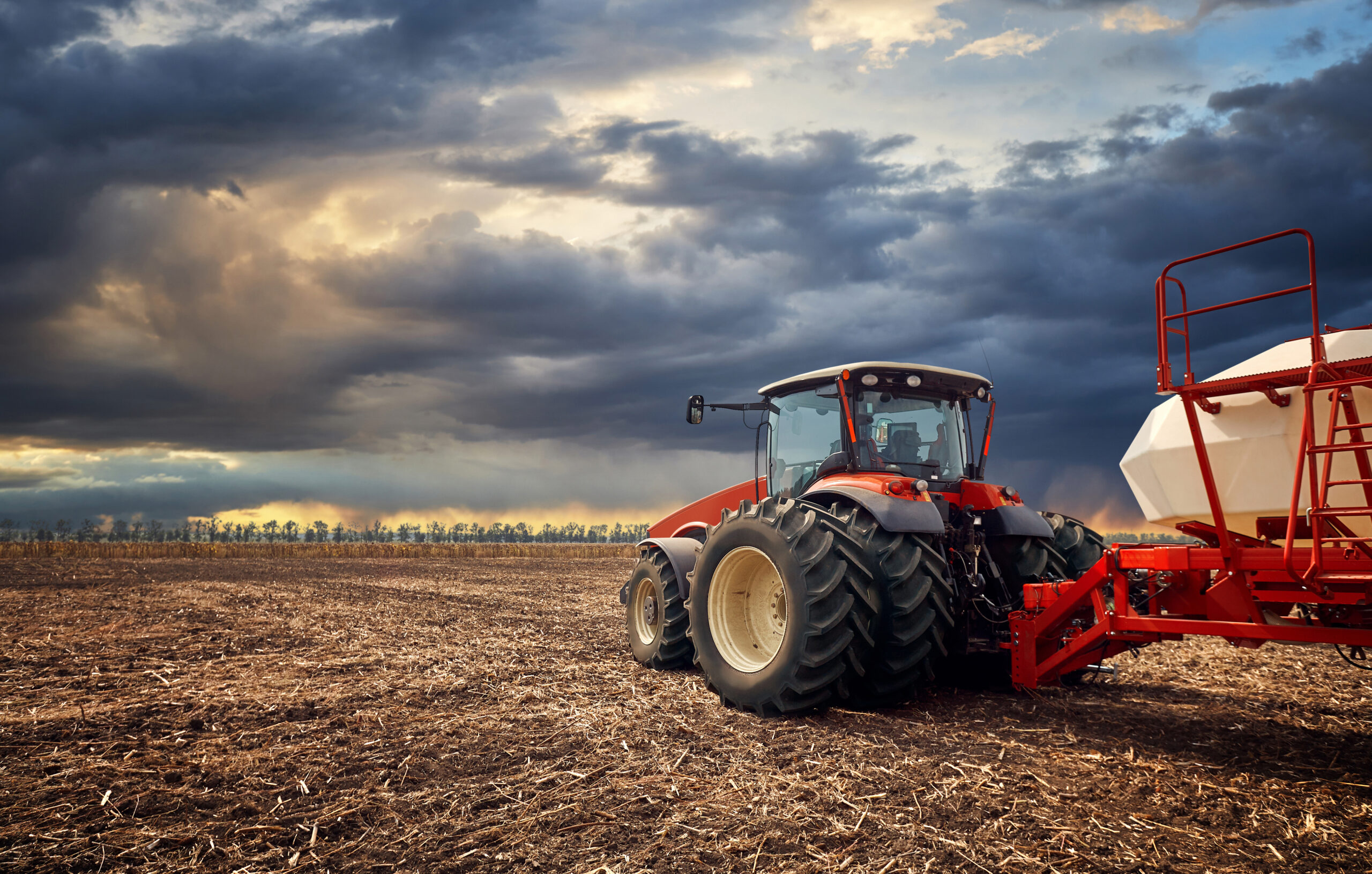 Tractor working on the farm, a modern agricultural transport, a farmer working in the field, fertile land, tractor on a sunset background, cultivation of land, agricultural machine